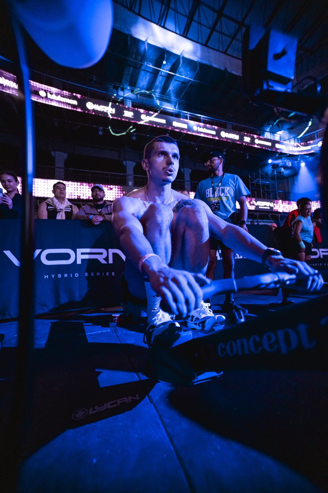 Atleta en el remo frente al público de VORN, con luz azul